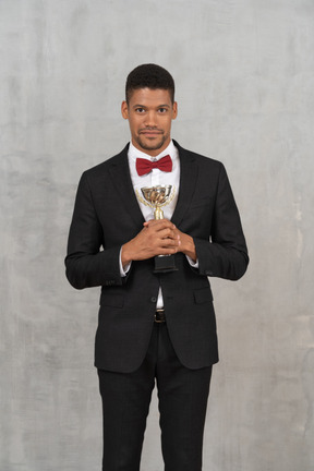 Smiling man in suit holding an award