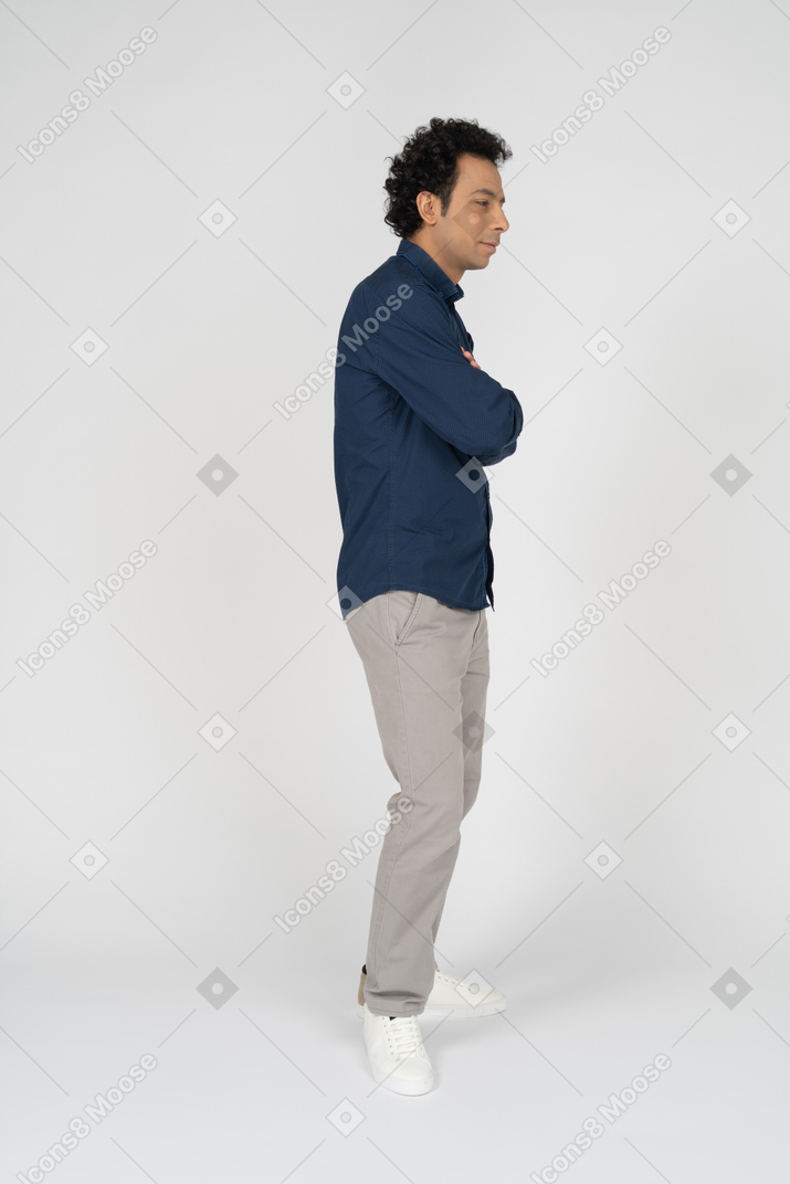 Side view of a man in casual clothes posing with crossed arms
