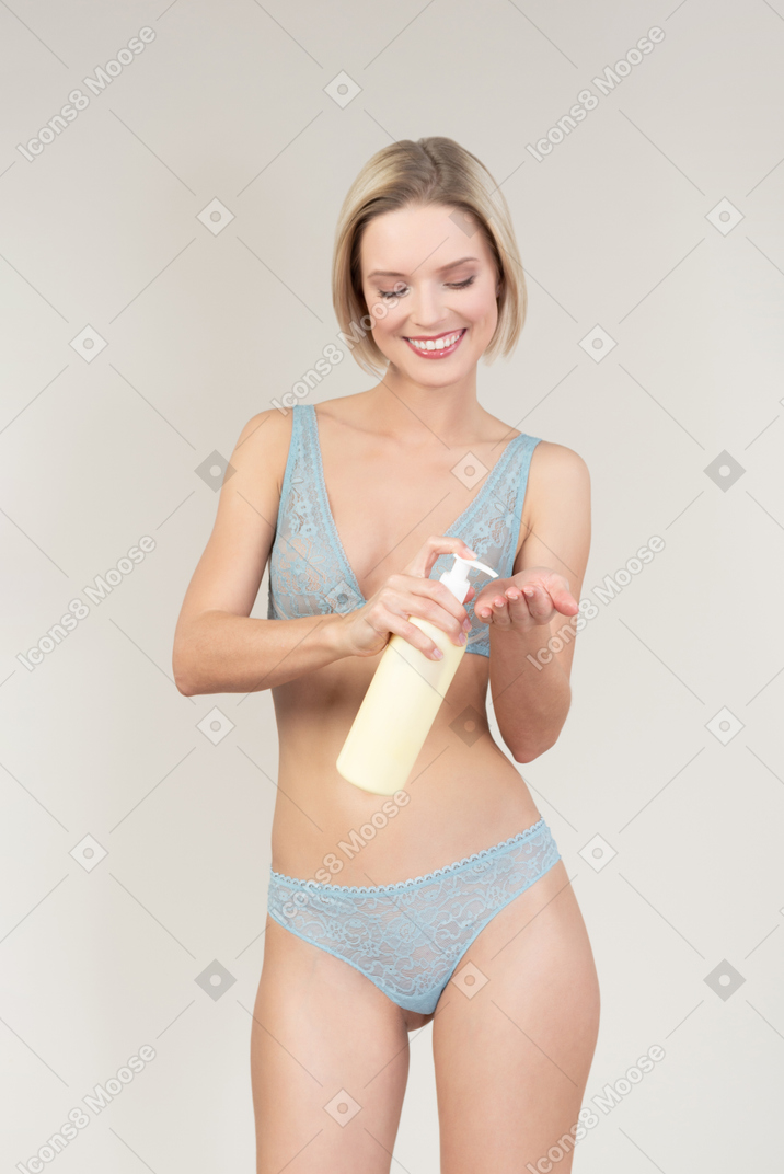 Sexy young woman applying body cream