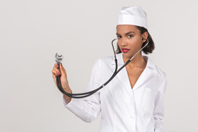 Séduisante jeune femme médecin tenant un stéthoscope