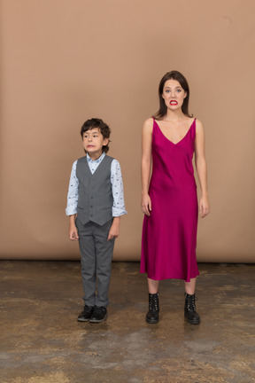 Vista frontal de um menino e uma mulher sorrindo com um vestido vermelho