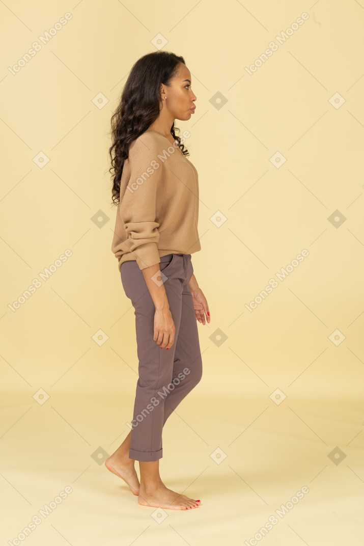 Side view of a young female in casual clothes walking