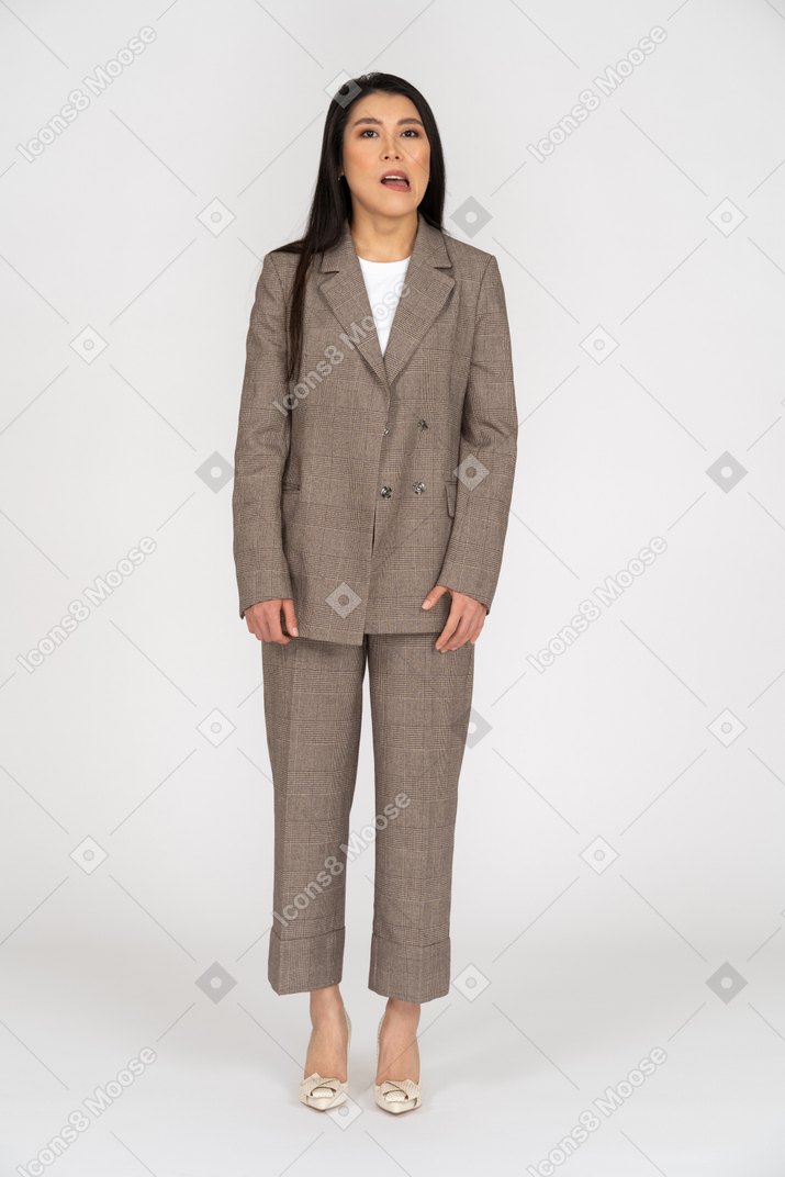 Front view of a grimacing young lady in brown business suit looking aside