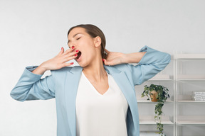 Woman yawning and covering mouth with hand