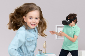 Jumping girl and boy wearing vr headset