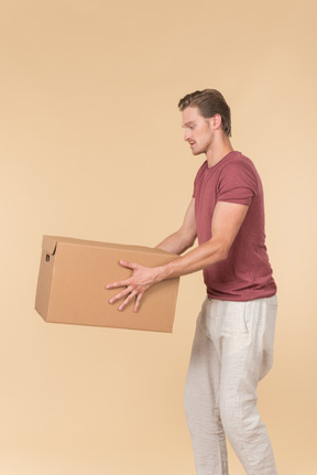 Delivery guy standing in profile and putting a parcel down