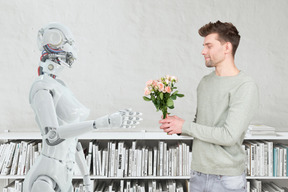 A man giving a bouquet of flowers to a robot