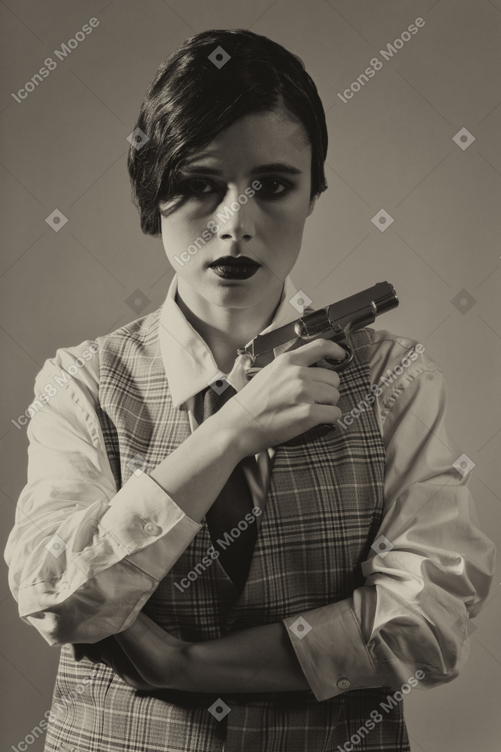 Close-up of a cheerless young woman with a gun