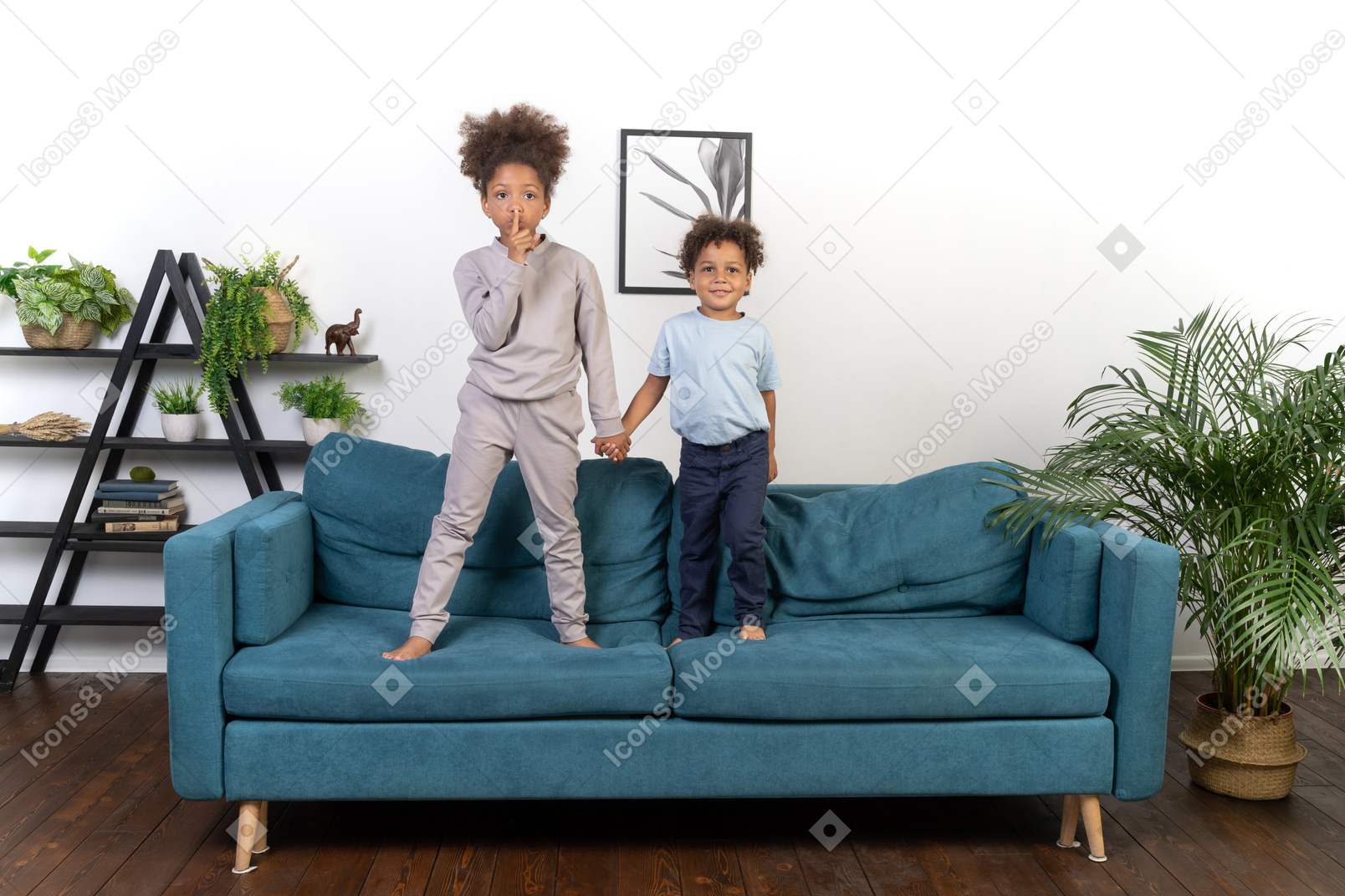 Cute boy and girl holding hands on sofa.