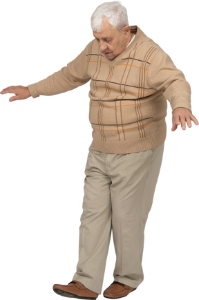 Vista frontal de un anciano con ropa informal caminando hacia adelante con los brazos extendidos
