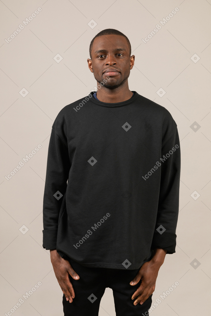 Young man standing still and looking at camera