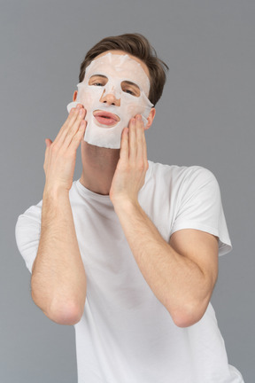 Front view of a young man posing in facial mask