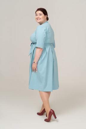 Vista laterale di una donna felice in abito blu