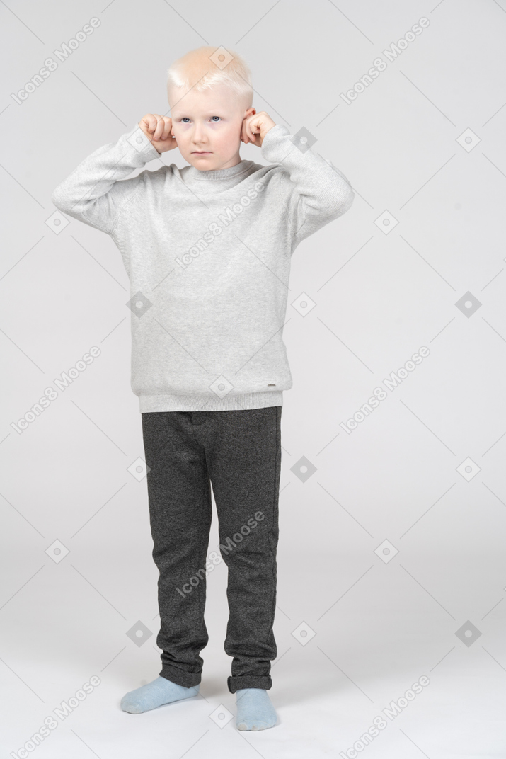 Little boy pulling his ears