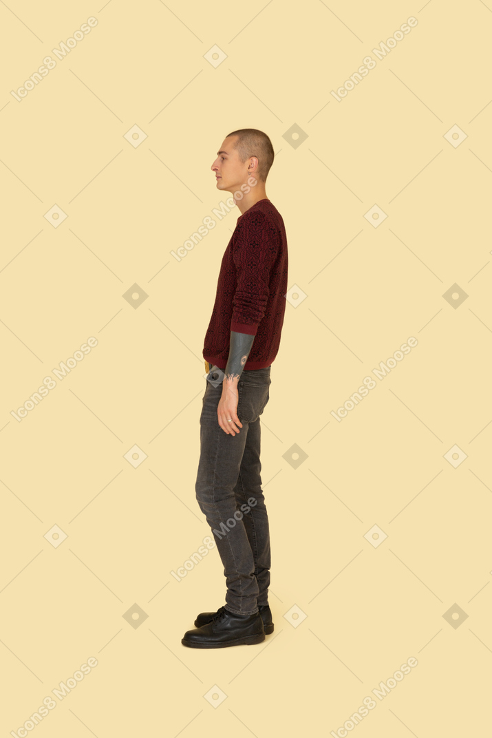 Vista laterale di un giovane uomo in un maglione rosso in piedi ancora