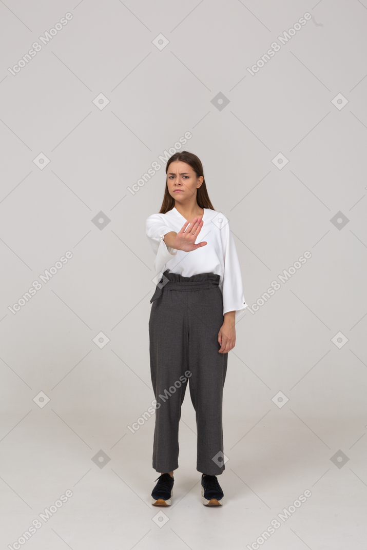 Front view of a displeased young lady in office clothing outstretching arm