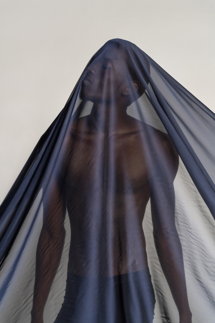 Front view of a young afro man covered with a dark blue shawl