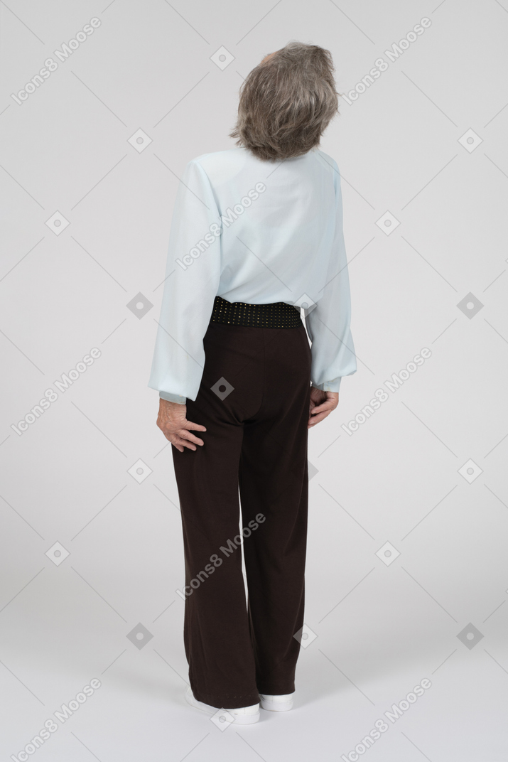 Vista posteriore di tre quarti di una donna anziana appoggiata allo schienale