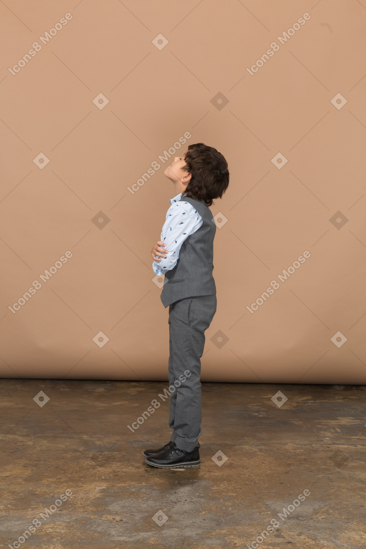 Vista laterale di un ragazzo in abito grigio che si abbraccia