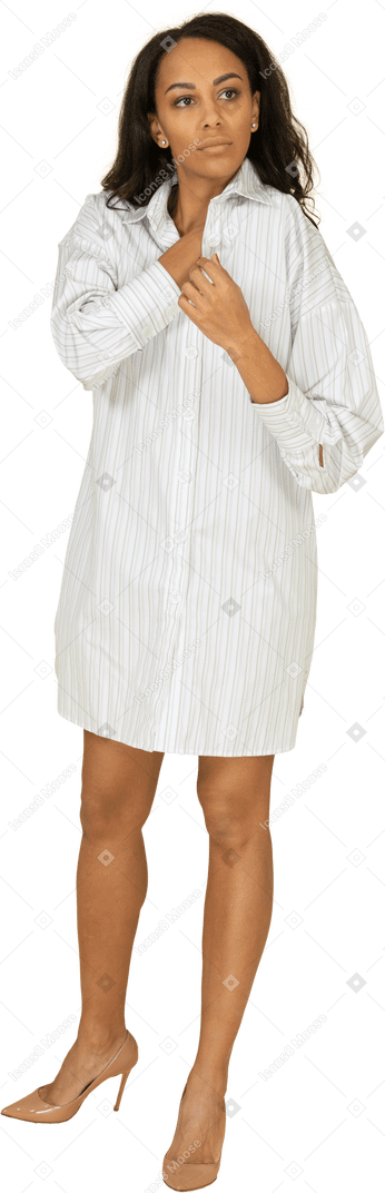 Vista frontale di una giovane femmina dalla carnagione scura che adegua il suo vestito bianco