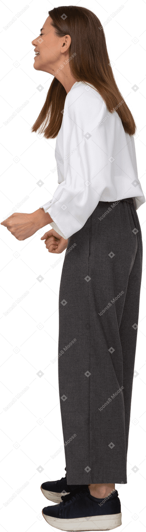 Side view of a crying young lady in office clothing clenching fists