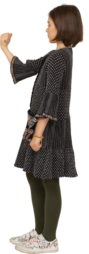 Side view of a little girl in dress clenching fist