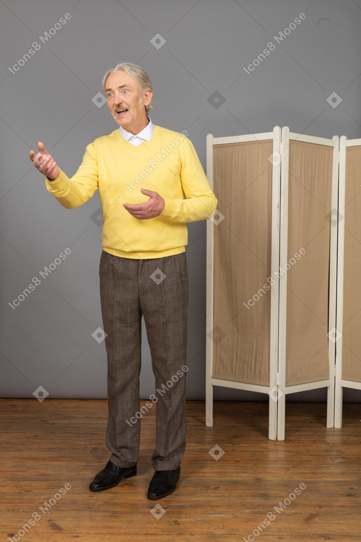 Three-quarter view of an old man explaining something while gesticulating