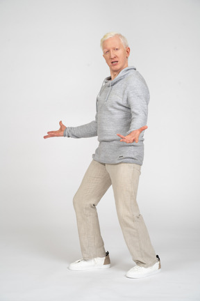 Man standing sideways and spreading his hands