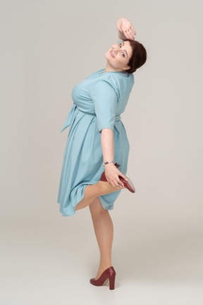 Woman in blue dress posing in profile