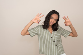 Attractive young girl showing ok sign with both hands