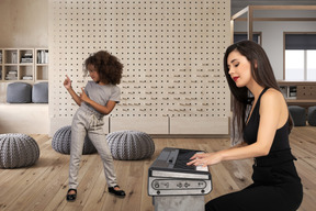 A woman playing on a synthesizer and little girl is dancing