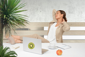 A woman sitting at a desk with a laptop and fruit