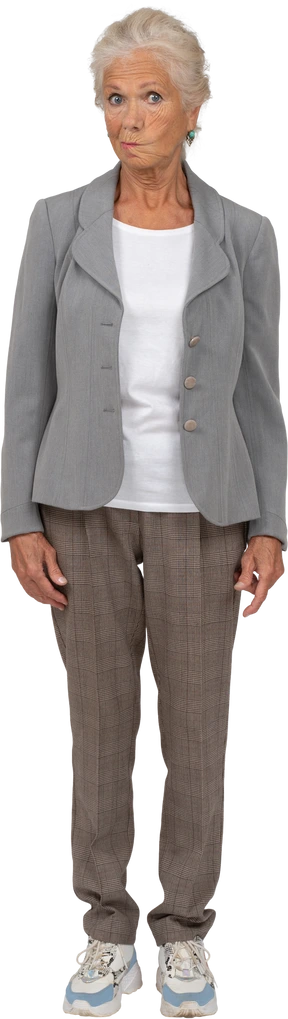 Vista frontal de una anciana en traje mirando a la cámara y haciendo muecas