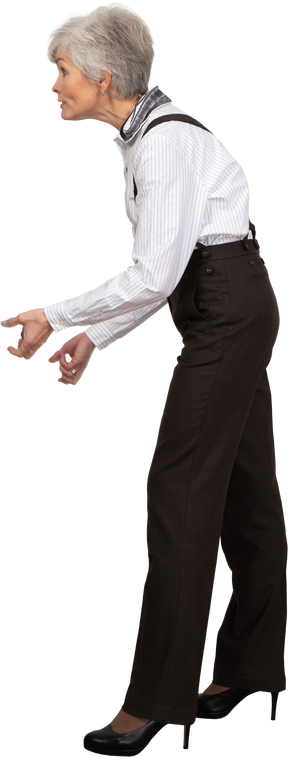 Side view of an old grimacing lady in office clothing clenching her fists