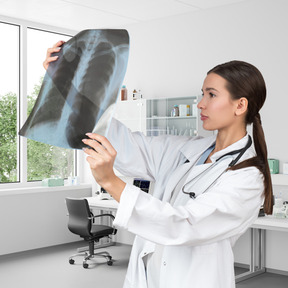 A female doctor holding up a x - ray image