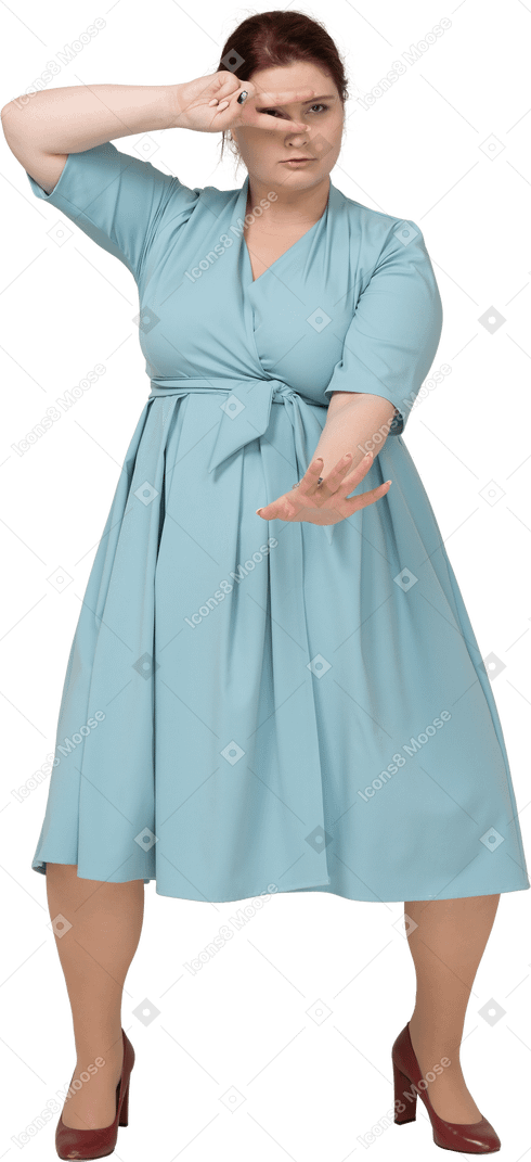 Вид спереди женщины в синем платье, показывающей знак v