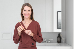 A woman holding a toothbrush in her hands