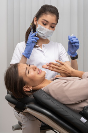 Woman scared of dentist holding a syringe