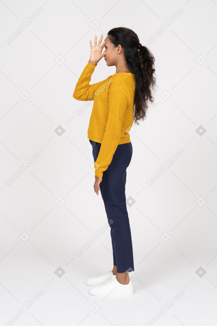 Side view of a girl in casual clothes touching face with a hand