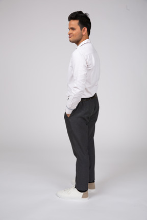 Side view of a man in office clothes with hands in pockets