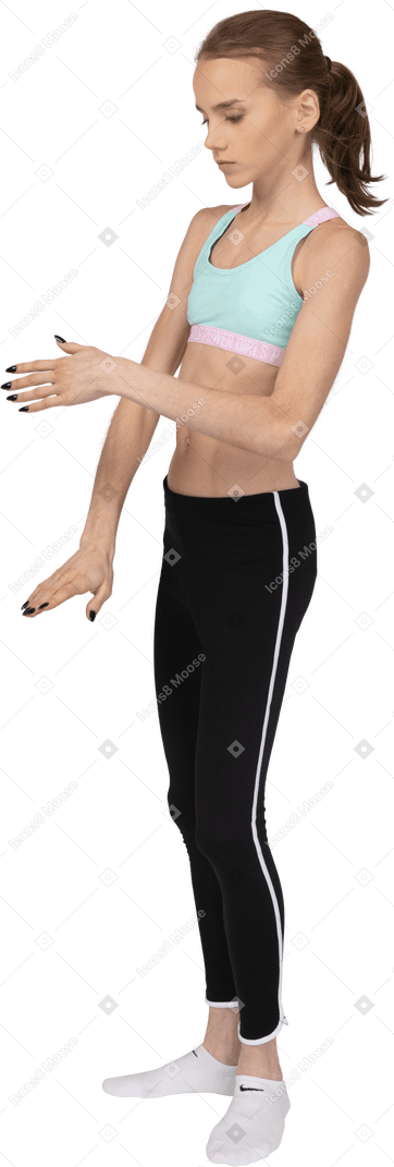 Vista lateral de uma adolescente em roupas esportivas estendendo a mão e tocando o braço