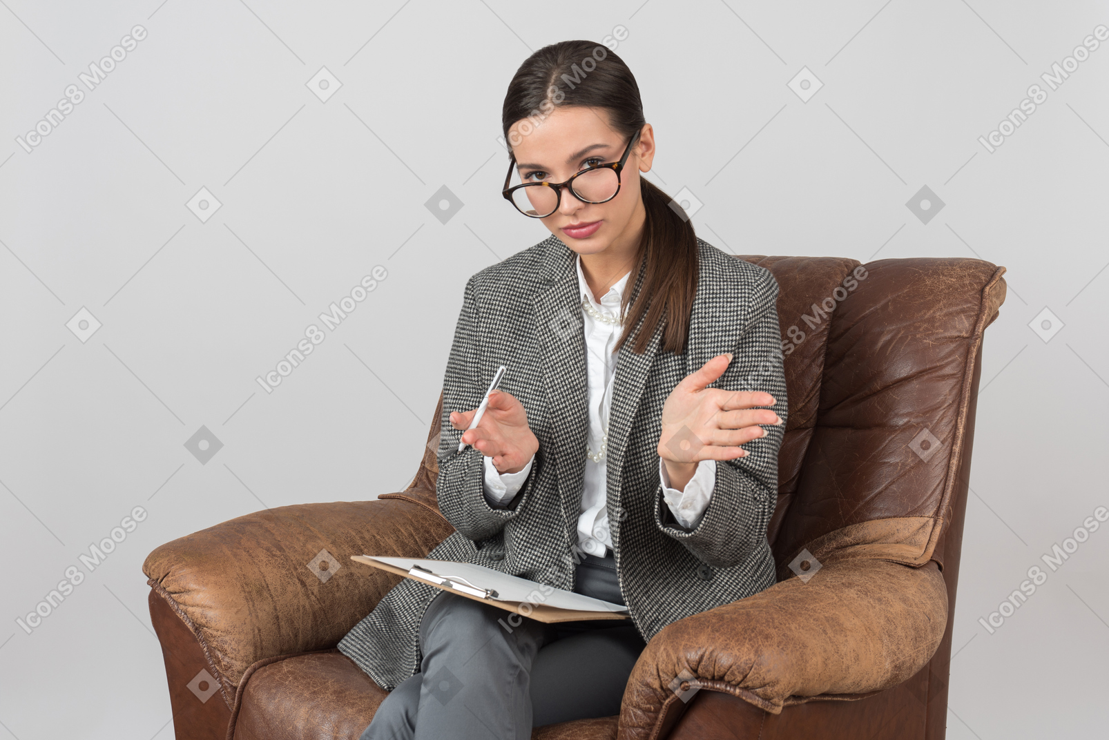 Involved in work young female psychologist sitting and showing something with her hands