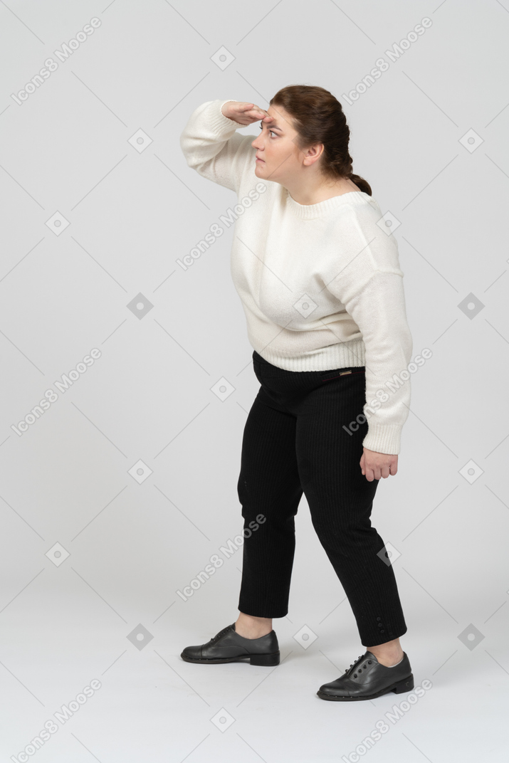 Vista lateral de uma mulher plus size com roupas casuais procurando por alguém