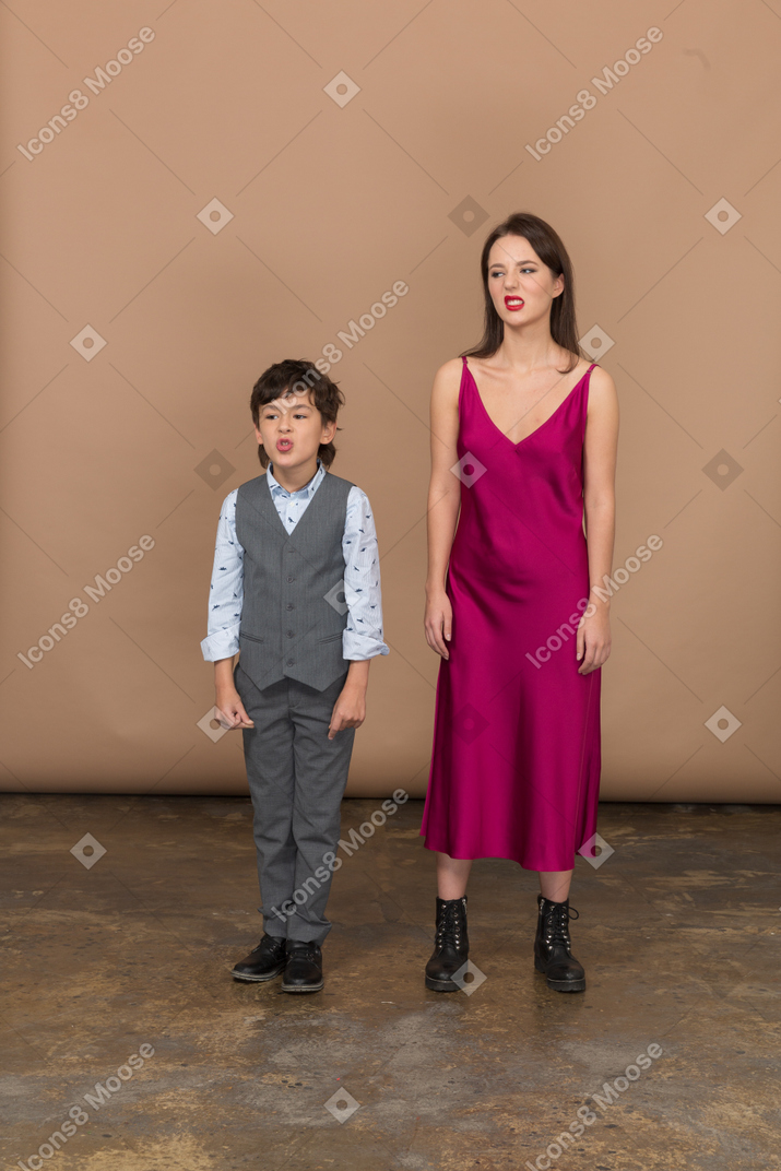 赤いドレスを着たニヤリと笑う男の子と女性の正面図