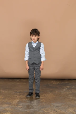 Front view of a boy in grey suit standing still