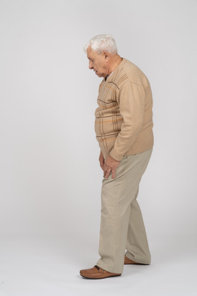 Seitenansicht eines alten mannes in freizeitkleidung mit blick nach unten