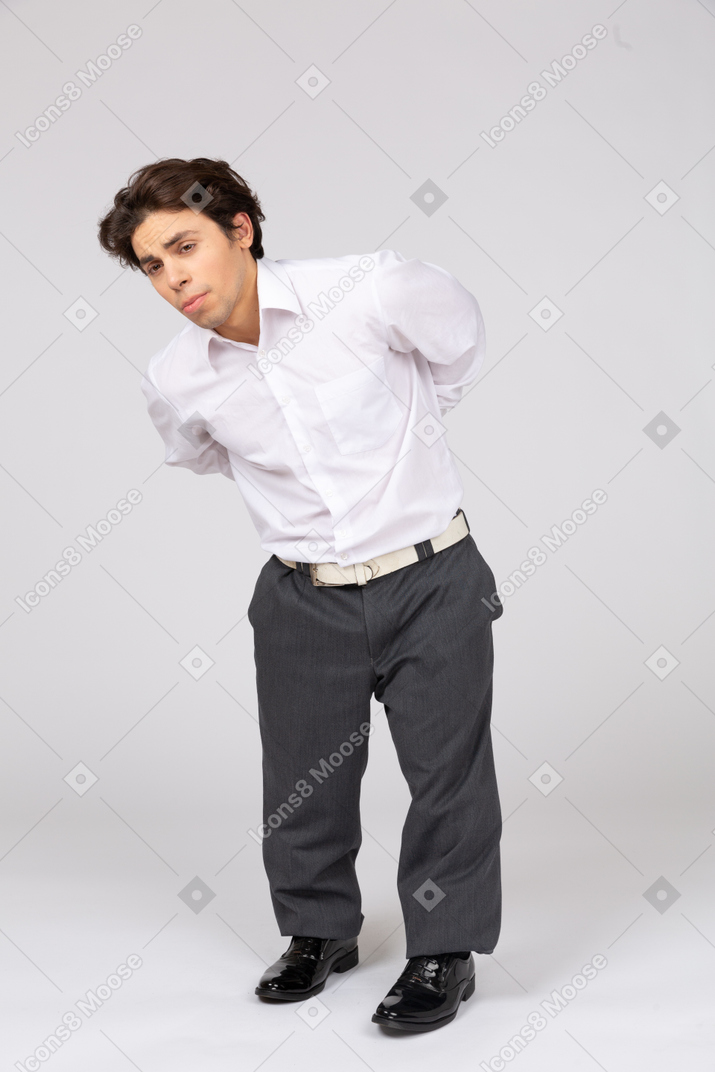 Man with hands behind back bending down