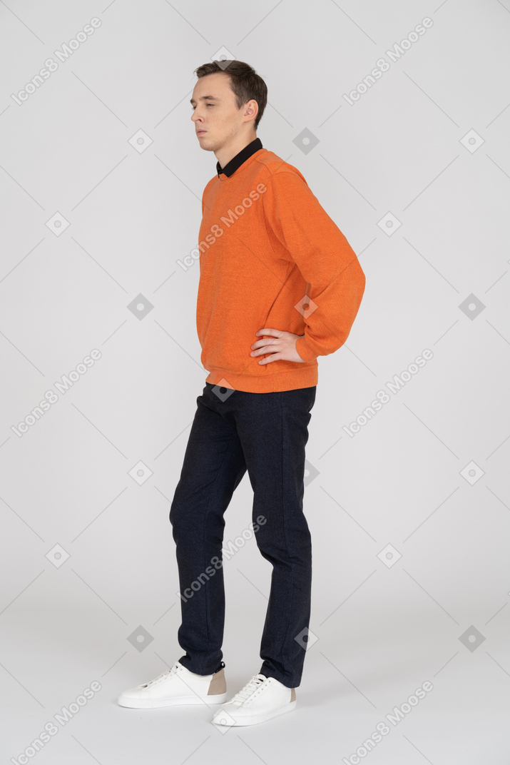 Junger mann im orangefarbenen sweatshirt stehend