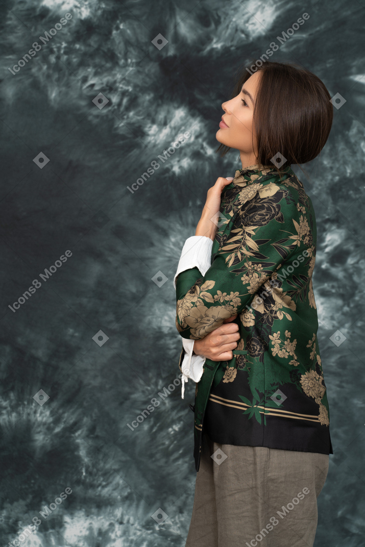 Ritratto laterale di giovane donna che tiene la sua giacca di seta