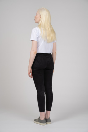 Vista traseira de uma garota em pé com cabelo loiro